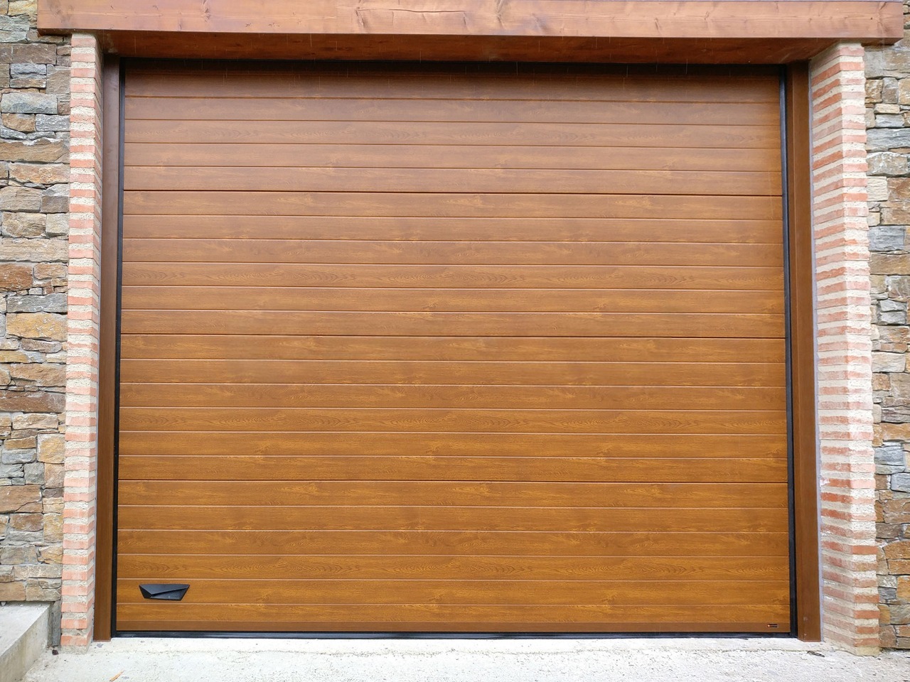 Porte sectionnelle imitation chêne clair sur villa moderne